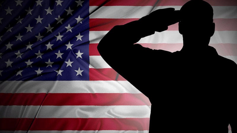 Soldier saluting in front of US flag